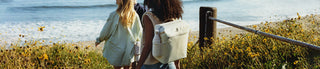 People walking to the beach with The All Day Madeleine Mini Cooler Backpack